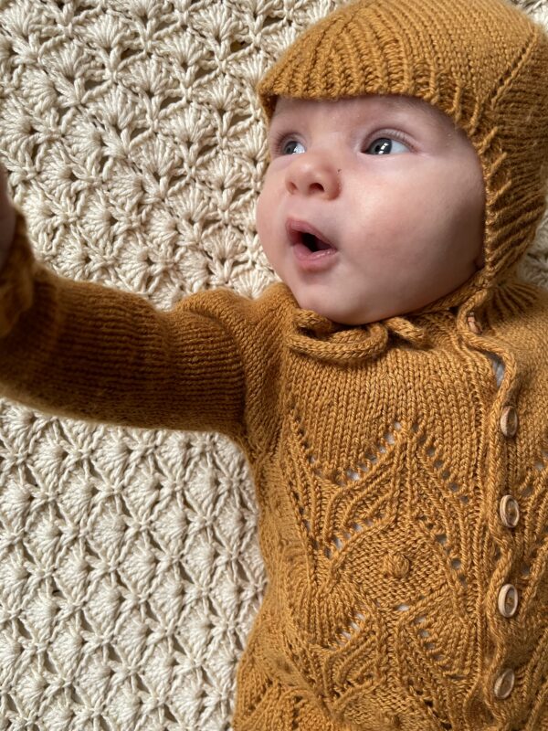 Baby i strikket hue og cardigan